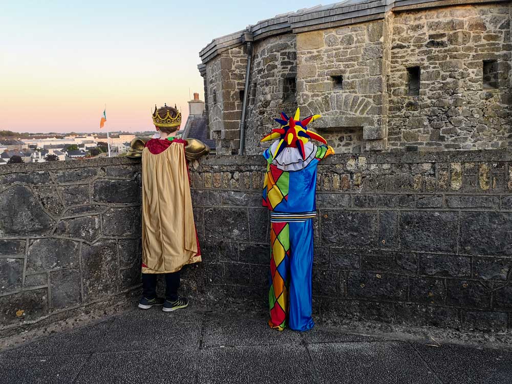 A young boy dressed as a King and his friend dressed as a Jester look down on to Athlone Castle’s courtyard.