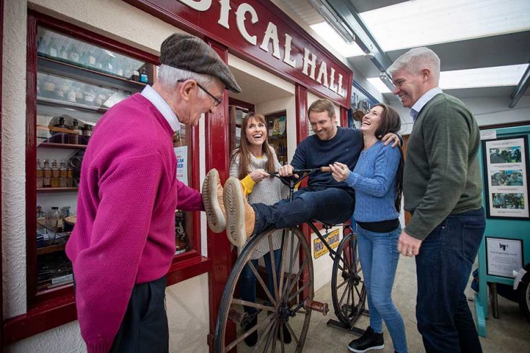 Visitors having fun on a vintage bicycle at Derryglad Folk Museum with owner Charlie. Just a short drive from Athlone Castle.