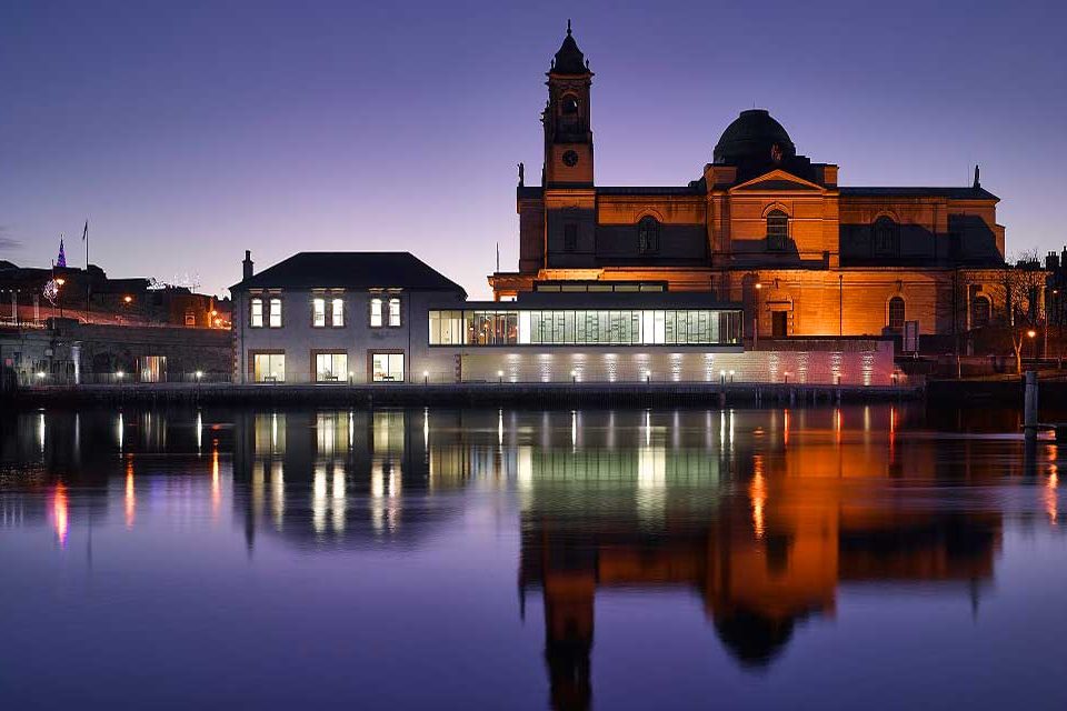 Beautiful night time view of Luan Gallery with St Peter and Paul’s Church in the foreground night casting wonderful shades of purple across the still waters of the River Shannon.