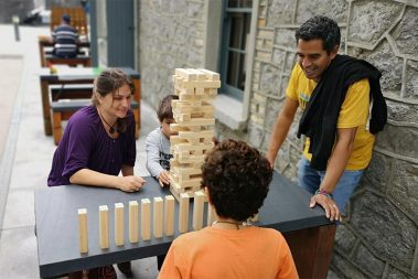 A family of four enjoying a game of Tumble Tower on a nice Summers day at the picnic benches in the Castle courtyard during the Traditional Games Day.