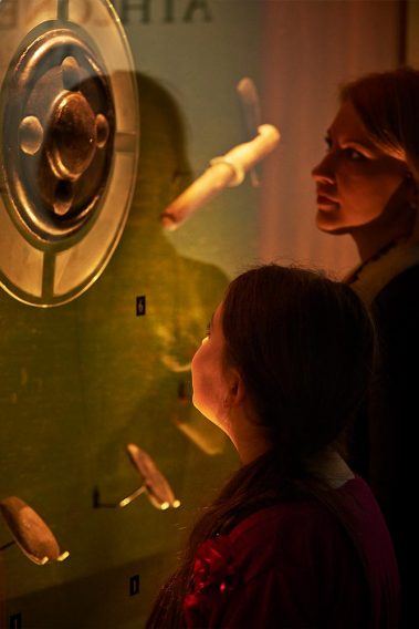Two visitors in awe of the Bronze shield that is on display in the Early History exhibition at Athlone Castle Visitor Centre.