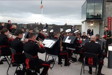The Band of the 2nd Brigade from Custume Barracks in Athlone preforming in the courtyard at Athlone Castle. The army band in full uniform seated in the courtyard playing trumpets and various other instruments to some visitors to Athlone Castle.