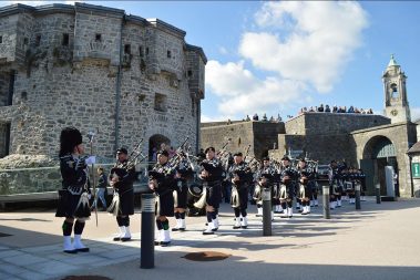 Seattle Police Pipe and Drum Band entertain onlookers from the upper battlements with a live band performance from the castle courtyard on a nice Summer’s day.