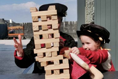 Two visitors enjoying game of tumbling tower at Athlone Castle Visitor Centre